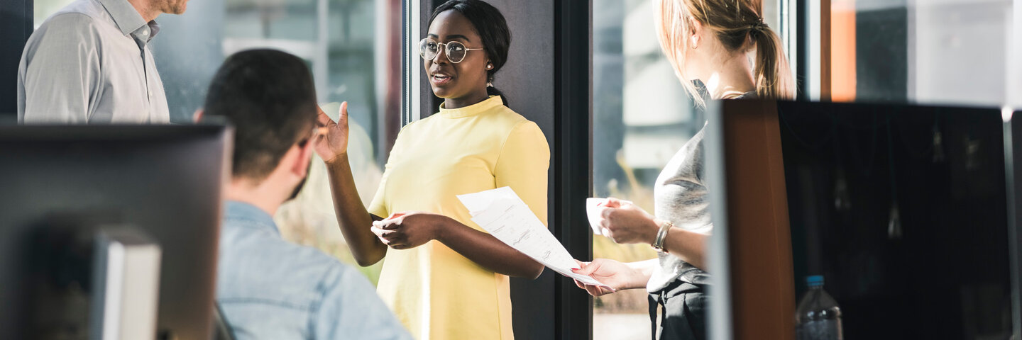 Professionals discussing ideas in an office, representing collaboration and leadership